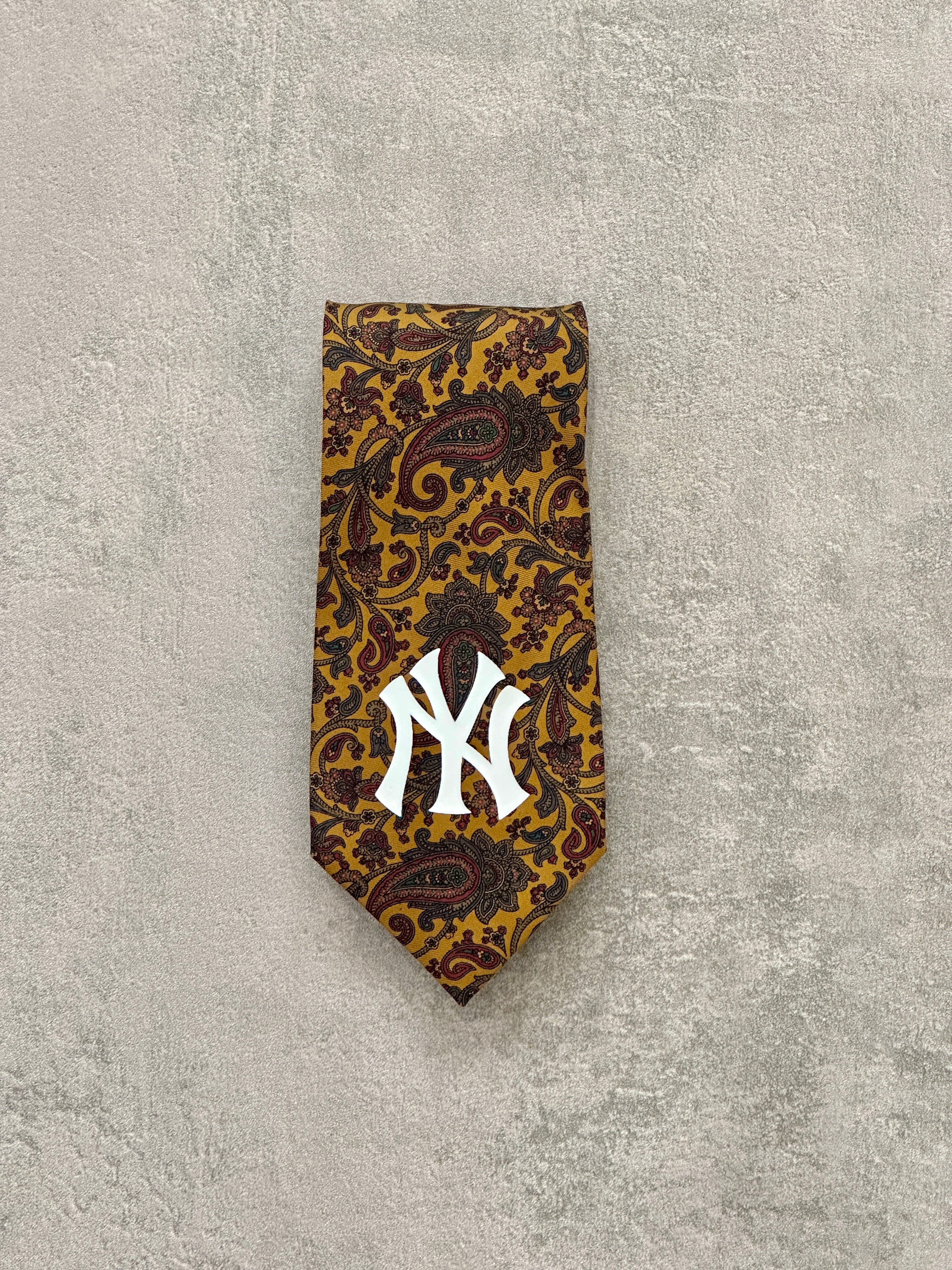 Cravatta vintage in seta con fantasia paisley e logo New York Yankees. Larghezza 9 cm. Accessorio unico per look streetwear e classy.